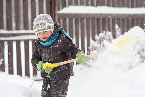 istock little boy cleans a shovel paths 621594438