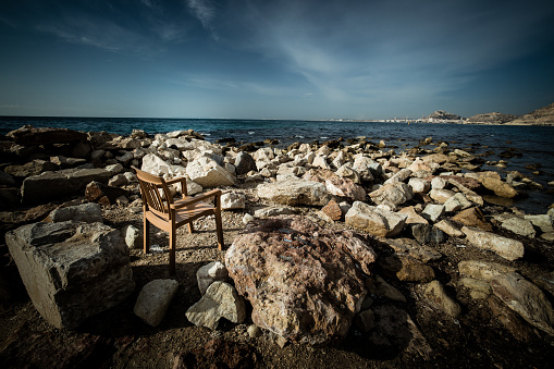 A fisherman's chair left on the rocks on Alicante beach.