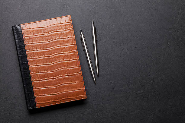 istock Office leather desk table with notepad, pen and pencil 621595978