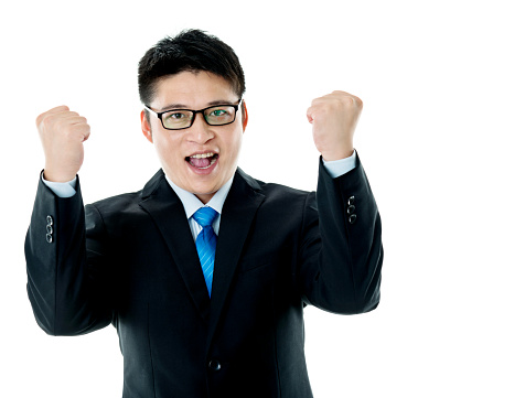 Excited young businessman cheering against white background.