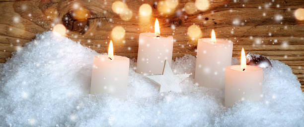 Christmas candles in the snow Advent candles in the snow with golden lights for a Christmas card funkeln stock pictures, royalty-free photos & images