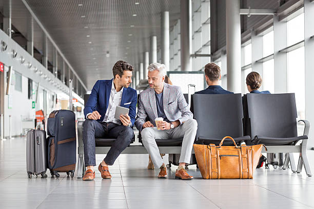 uomini d'affari in attesa del loro volo - people traveling business travel waiting airport foto e immagini stock