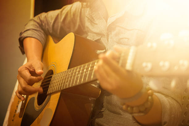 istock woman's hands playing acoustic guitar 621600870