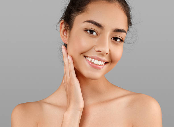 hermosa cara de mujer joven con piel perfecta. fondo gris - modelo de artista fotografías e imágenes de stock