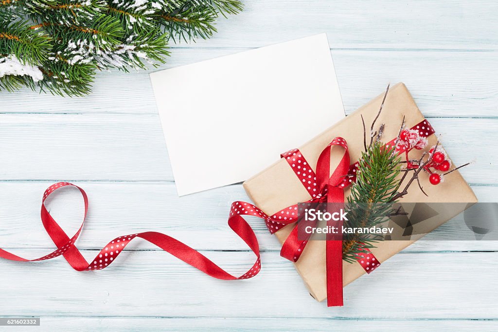 Christmas gift box and greeting card Christmas gift box and greeting card on wooden background. Top view with copy space Christmas Present Stock Photo