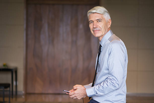 istock Serious Senior Businessman Using Smartphone 621602502