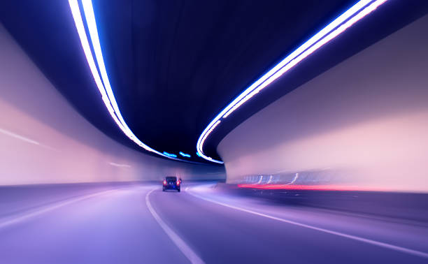 auto che si muove nel tunnel - rush hour flash foto e immagini stock