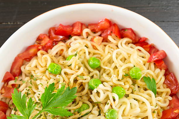 istock noodles with tomato and peas in a bowl 621607162