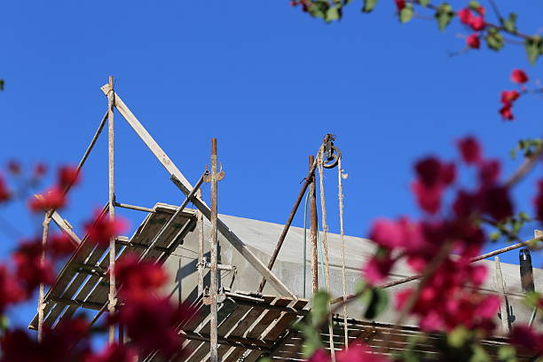 plac budowy przez bush z czerwonymi kwiatami. - scaffolding wheel construction site metal zdjęcia i obrazy z banku zdjęć