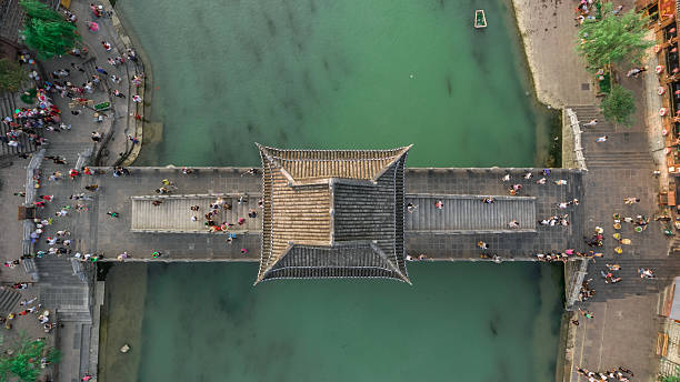 Aerial Shot of Stone Bridge in Fenghuang County Top View or Aerial Shot of Famous Stone Old Fashioned Chinese Bridge in Ancient Town in Fenghuang County, China. Aerial View of Stone Bridge over Green River, Crowds of People. phoenix stone stock pictures, royalty-free photos & images