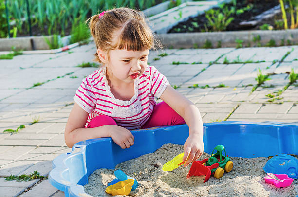 istock little girl playing in a sandbox 621611880