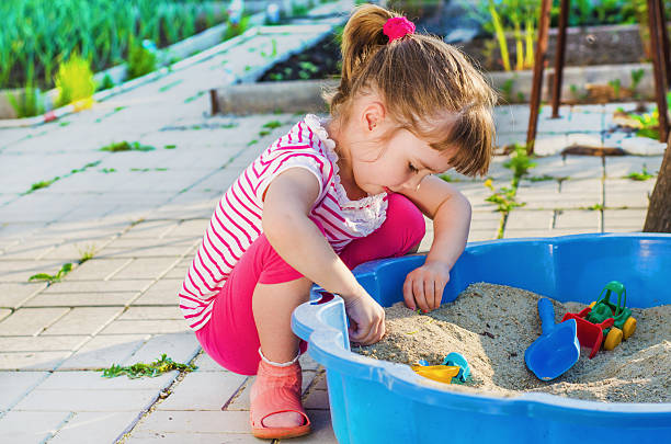 istock little girl playing in a sandbox 621612028
