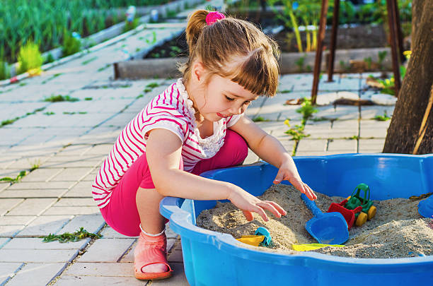 istock little girl playing in a sandbox 621612080
