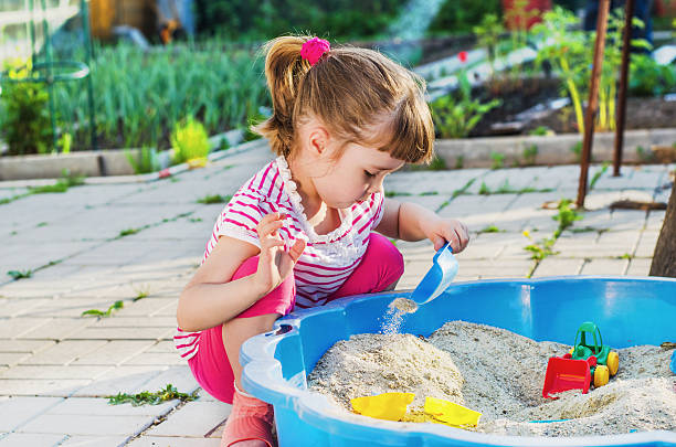 little girl playing in a sandbox - sandbox child human hand sand imagens e fotografias de stock