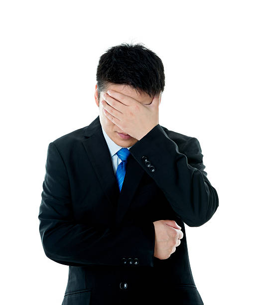 istock Disappointed young businessman covering eyes with hand 621612404