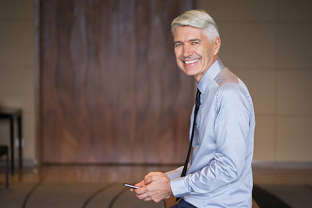 istock Smiling Senior Businessman Using Smartphone 621612938