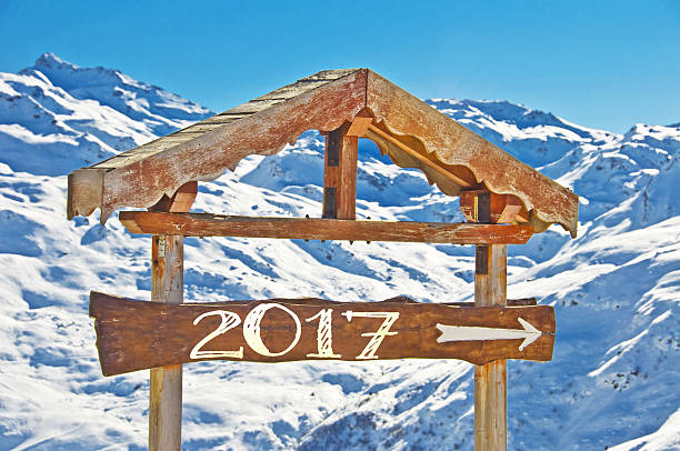 istock 2017 written on a wooden direction sign, snowy mountain 621613534
