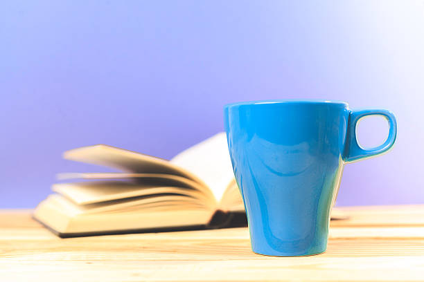 istock Color cup of tea with book on table 621614584