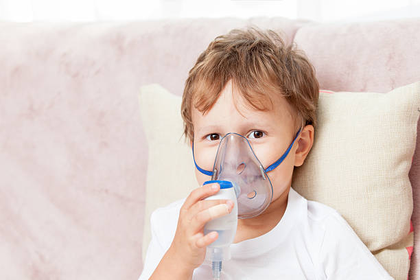 istock Boy making inhalation with a nebulizer at home 621615968