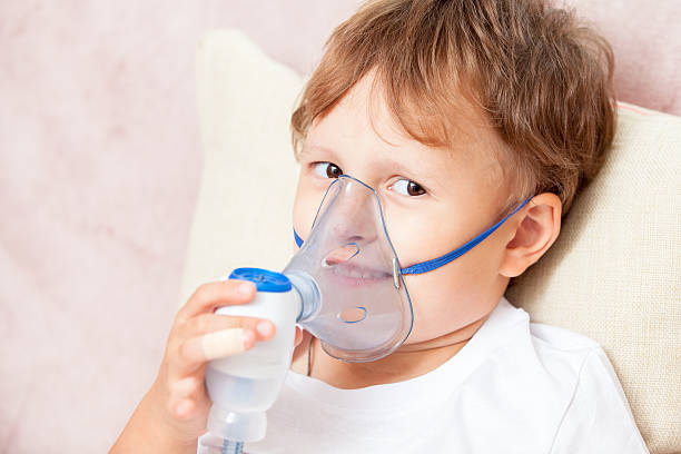 istock Boy making inhalation with a nebulizer at home 621616030