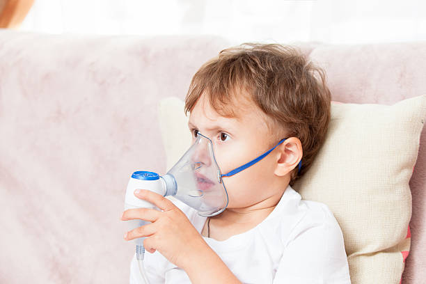 istock Boy making inhalation with a nebulizer at home 621616084