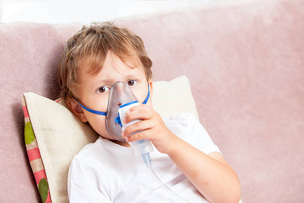 istock Boy making inhalation with a nebulizer at home 621616212