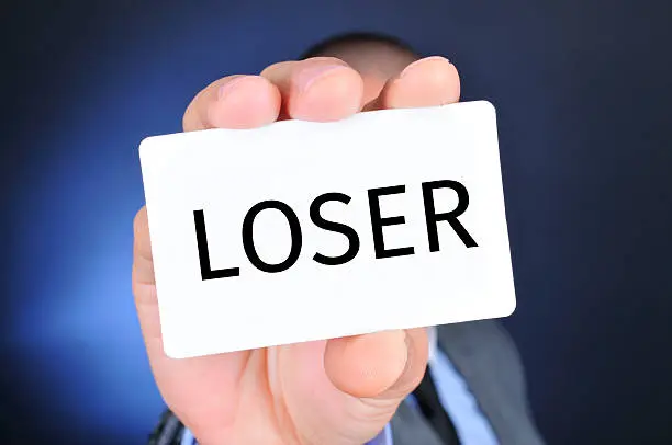 Photo of man with a signboard with the word loser