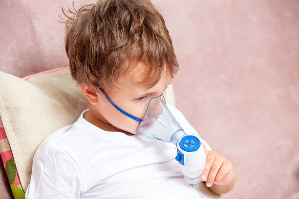 istock Boy making inhalation with a nebulizer at home 621616370