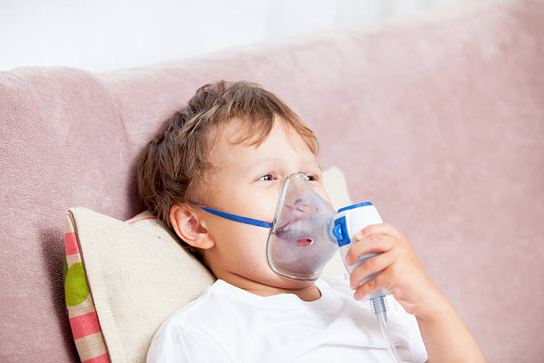 istock Boy making inhalation with a nebulizer at home 621616500