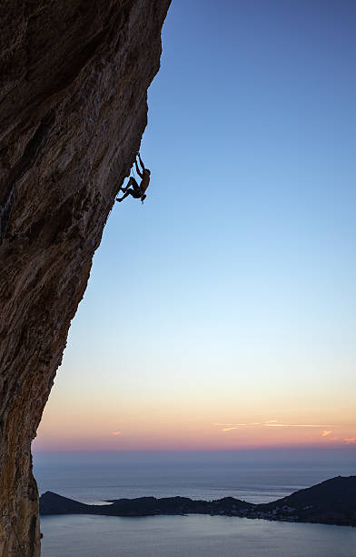 istock Rock climber on overhanging cliff at sunset 621616818