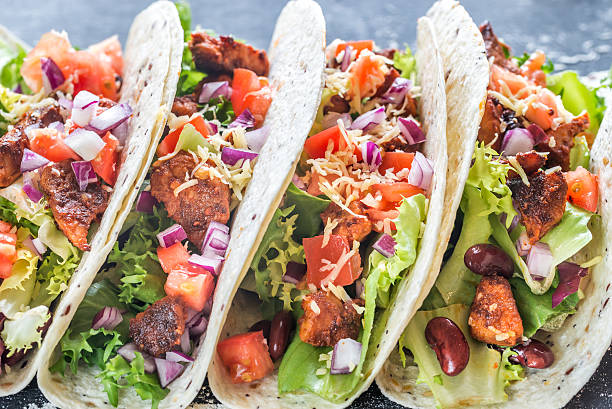 istock Four mexican tacos on a black background 621686186