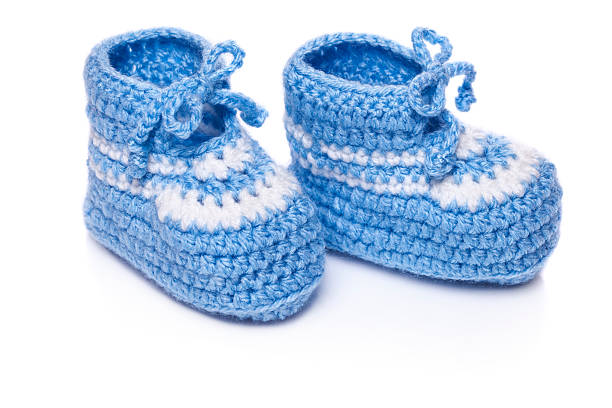 Homemade knitted baby blue booties isolated on white background