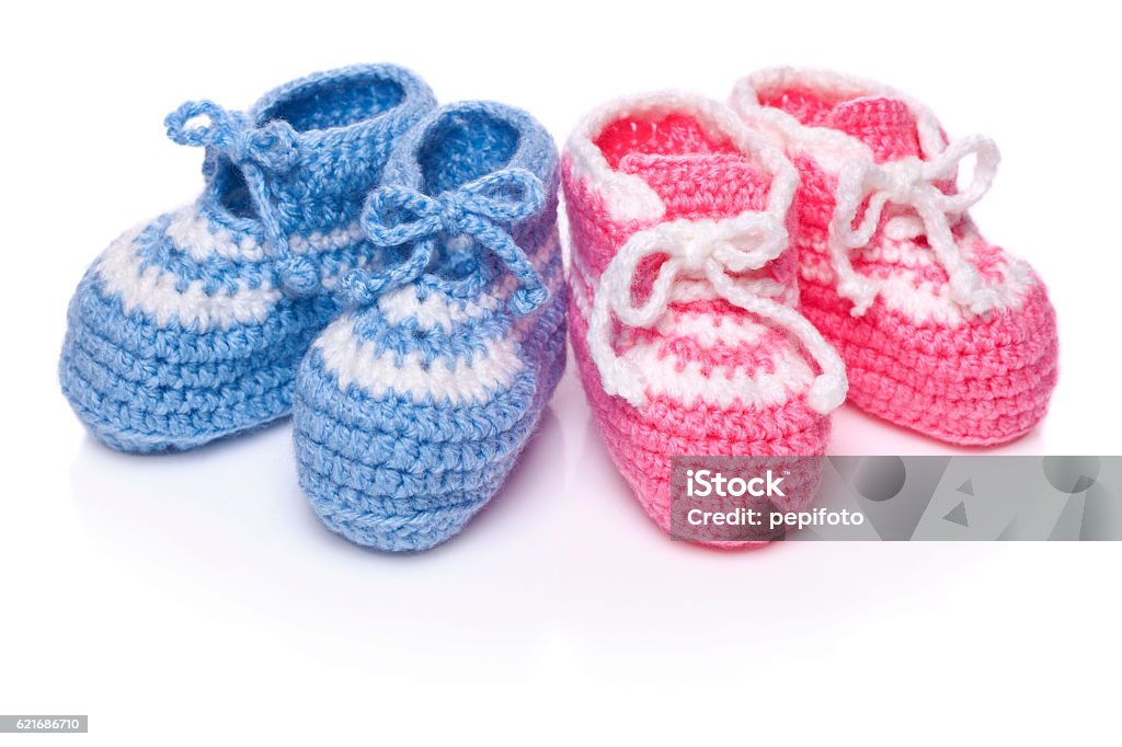Homemade knitted baby blue and pink booties Homemade knitted baby blue and pink booties isolated on white background Twin Stock Photo