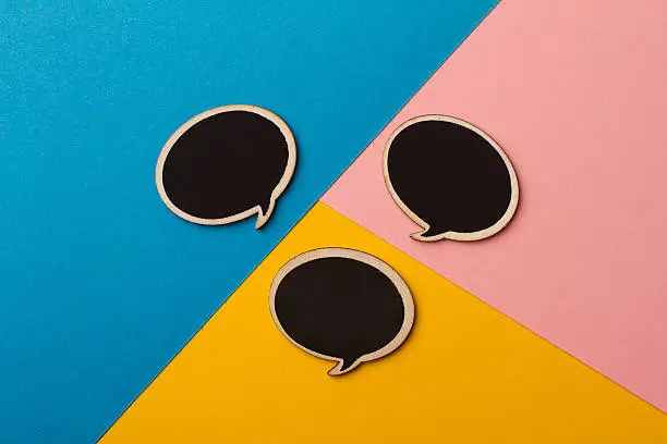 Photo of Round empty chalk board speech bubbles on colored papers