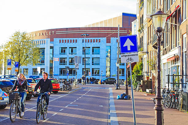 Amsterdam, Netherlands - May 1, 2016: Commuter are riding a bicycle on their way through the city in Amsterdam. Bicycle is traditional transport system in Netherlands. Many commuters are using bicycles in Amsterdam. More than 60٪ of trips in the center of Amsterdam are made by bike, Netherlands