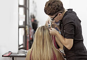 Woman hairstylist working on blonde woman client