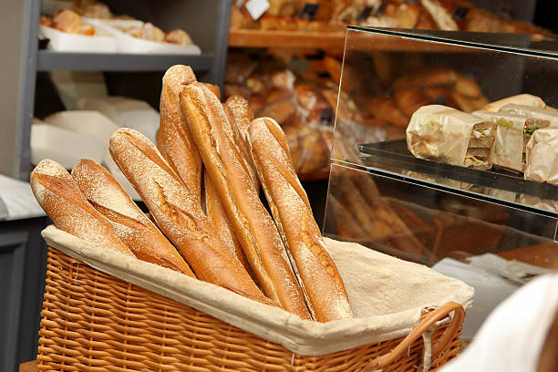 french baguettes in wicker basket in bakery - baguette stok fotoğraflar ve resimler