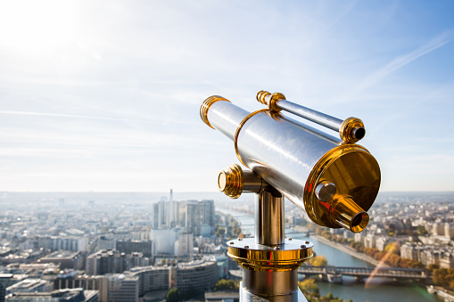 The telescope stands on the bank of River. The pipe is in focus, and the shore opposite is out of focus.