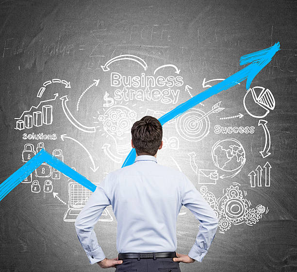 istock Businessman in blue shirt looking at blue graph 621698356