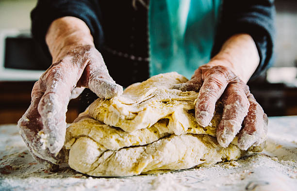 istock old  italian lady's hands making home made italian pasta 621698712
