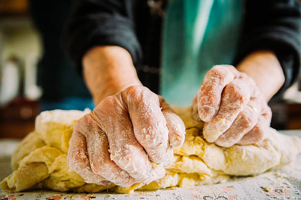 close up of old  italian lady's hands making italian pasta - country bread imagens e fotografias de stock