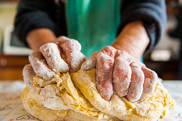 old italian  lady's hands preparing home made italian pasta stock photo