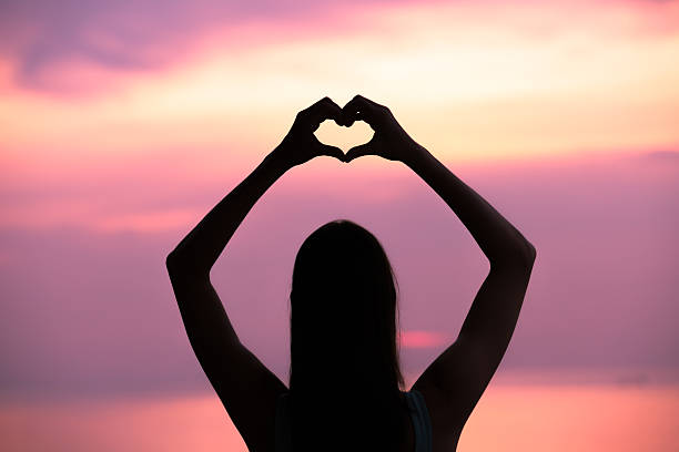 istock Woman making a hand shaped heart at sunset. 621700012