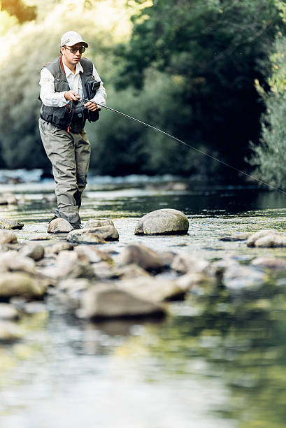 istock Fly fisherman using flyfishing rod. 621700444