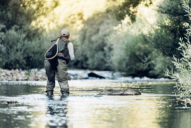 istock Fly fisherman using flyfishing rod. 621700706
