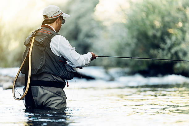 istock Fly fisherman using flyfishing rod. 621700714