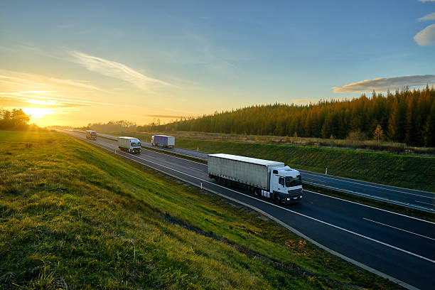 istock Trucks driving on the expressway in autumn landscape at sunset. 621700948