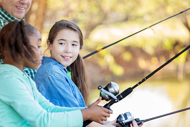istock Diverse sisters fish with their grandfather 621702796