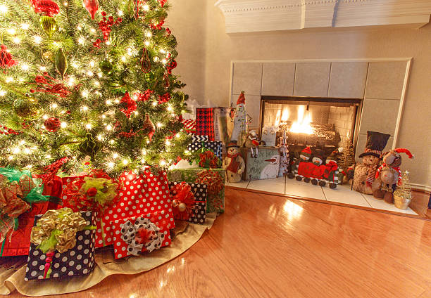 istock Christmas tree with wrapped gifts next to a fire place 621703676