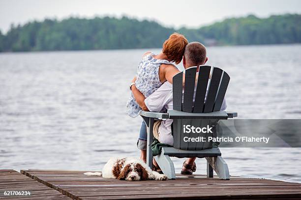 Pareja En El Muelle Con Perro Foto de stock y más banco de imágenes de Lago - Lago, Eventos de la vida, Familia